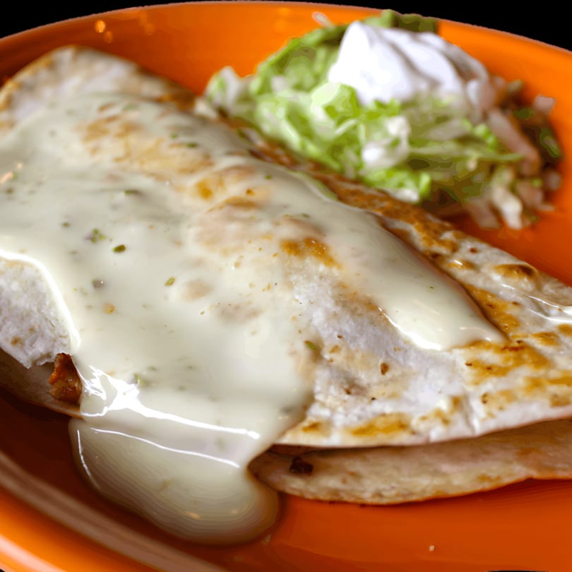 A Dos Reales quesadilla covered in white cheese sauce, served with shredded lettuce and sour cream.